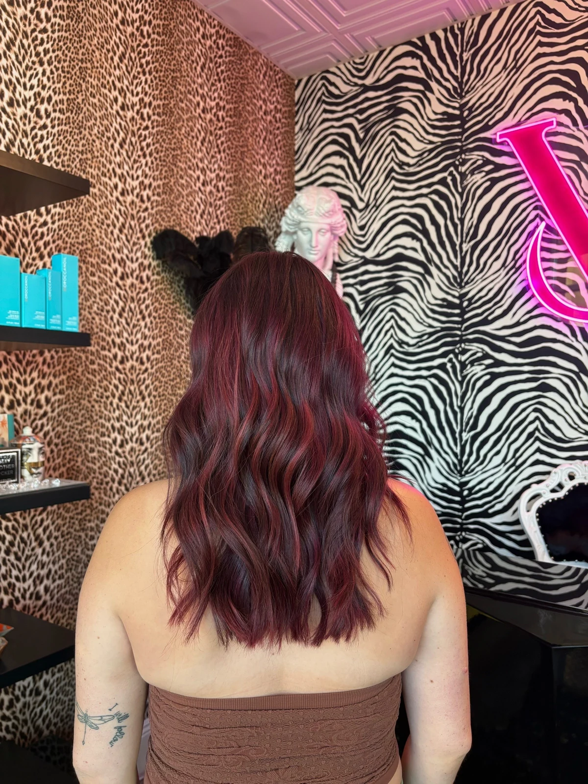 Back view of long burgundy hair color styled in waves